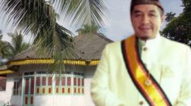 Raǰa Huristak Tondi Hasibuan dengan latarbelakang Bagas Godang Huristak, sisa peninggalan Kerajaan Huristak. (Dok. Montase Sepintas.com)